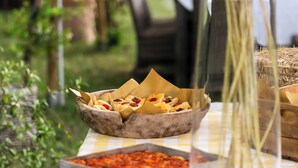 Una mesa con alimentos, un florero y un mantel a cuadros.