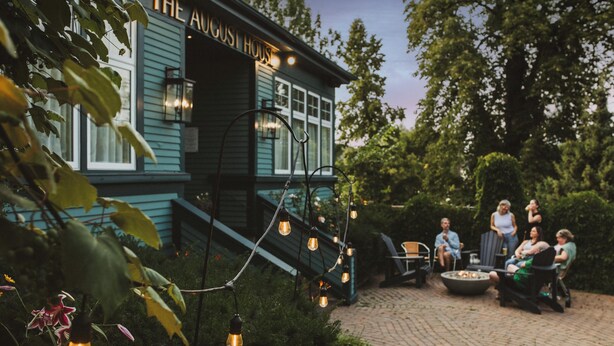 Ein Gebäude mit dem Namen 'The August House', Außenbereich und Lichterketten.