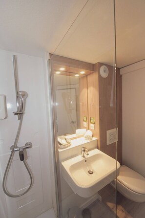 Un baño moderno con ducha, lavabo e inodoro.