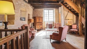 A rustic room with wooden beams, a staircase, and traditional furniture. - Beautiful Périgourdine house with pool access Hôtel La Roseraie (Montignac-Lascaux)