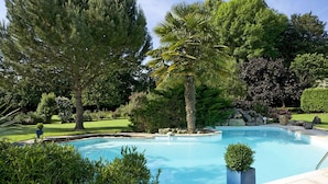 A swimming pool surrounded by lush greenery and trees. - Beautiful Périgourdine house with pool access Hôtel La Roseraie (Montignac-Lascaux)