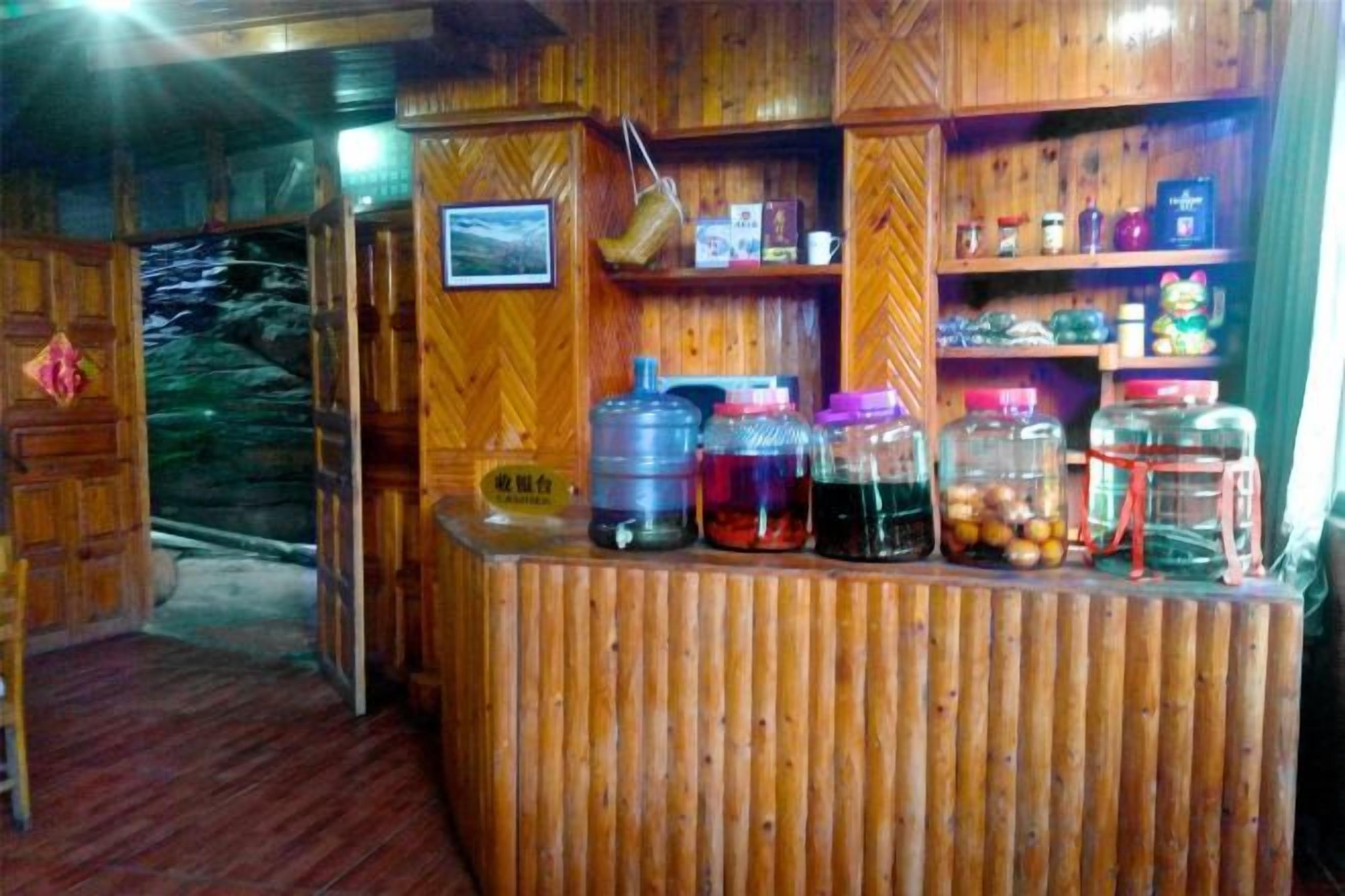 A wooden reception desk with various containers, a hanging light, and a wooden wall with shelves.