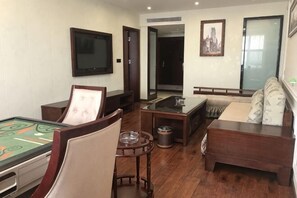 Ein Zimmer mit Pooltisch, einer Couch, einem Fernseher und einer Tür zu einem anderen Raum.
