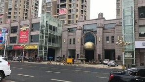 A multi-story building with a prominent glass facade and a large, rounded entrance. - Wangxinge Hotel (Nan County)