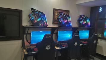 A gaming setup with multiple monitors, RGB lighting, and gaming chairs.