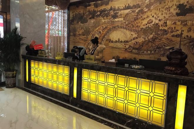 Un mostrador de recepción con un gran mural de fondo.