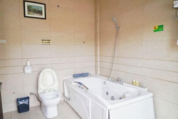 A bathroom with a toilet, bathtub, and shower.