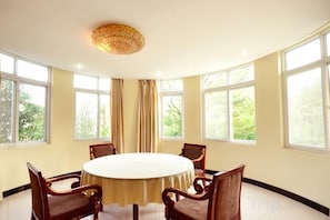 A conference room with a round table, six chairs, and large windows. - Tianzi Lake Ecological Resort (Xiaogan)
