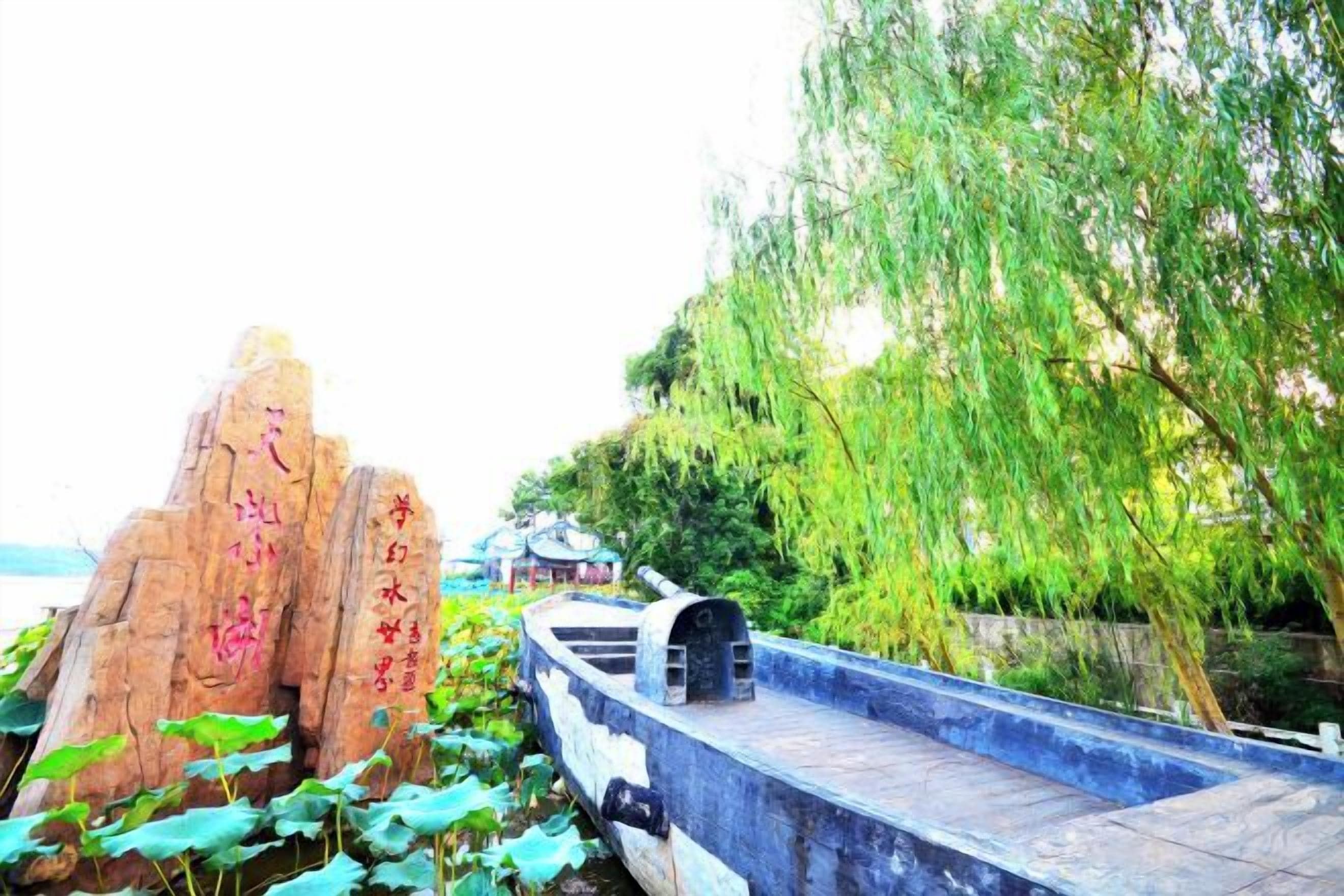 A stone structure with inscriptions, a bridge, and a weeping willow tree.
