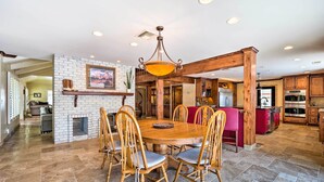 A spacious kitchen with wooden cabinets, a central island, and a dining area with a round table and chairs. - Pool & Putting Green: Group Getaway in Glendale! (Glendale)