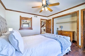 Une chambre à coucher avec un lit, un ventilateur de plafond, une commode et un miroir.
