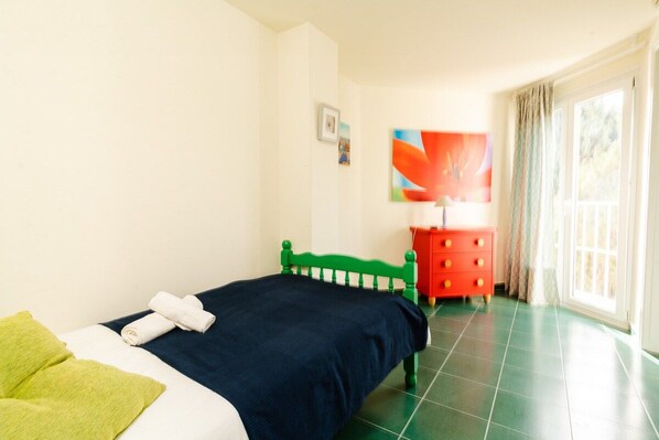 Un dormitorio con cama, cómoda, un cuadro y ventana.