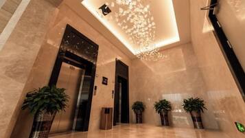 En moderne lobby med gulv i skinnende stand, en reception og en lampe i loftet.