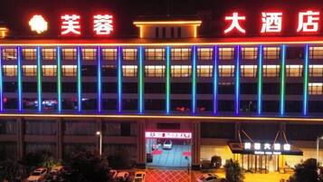 A hotel with a modern facade, multiple floors, and a brightly lit entrance.
