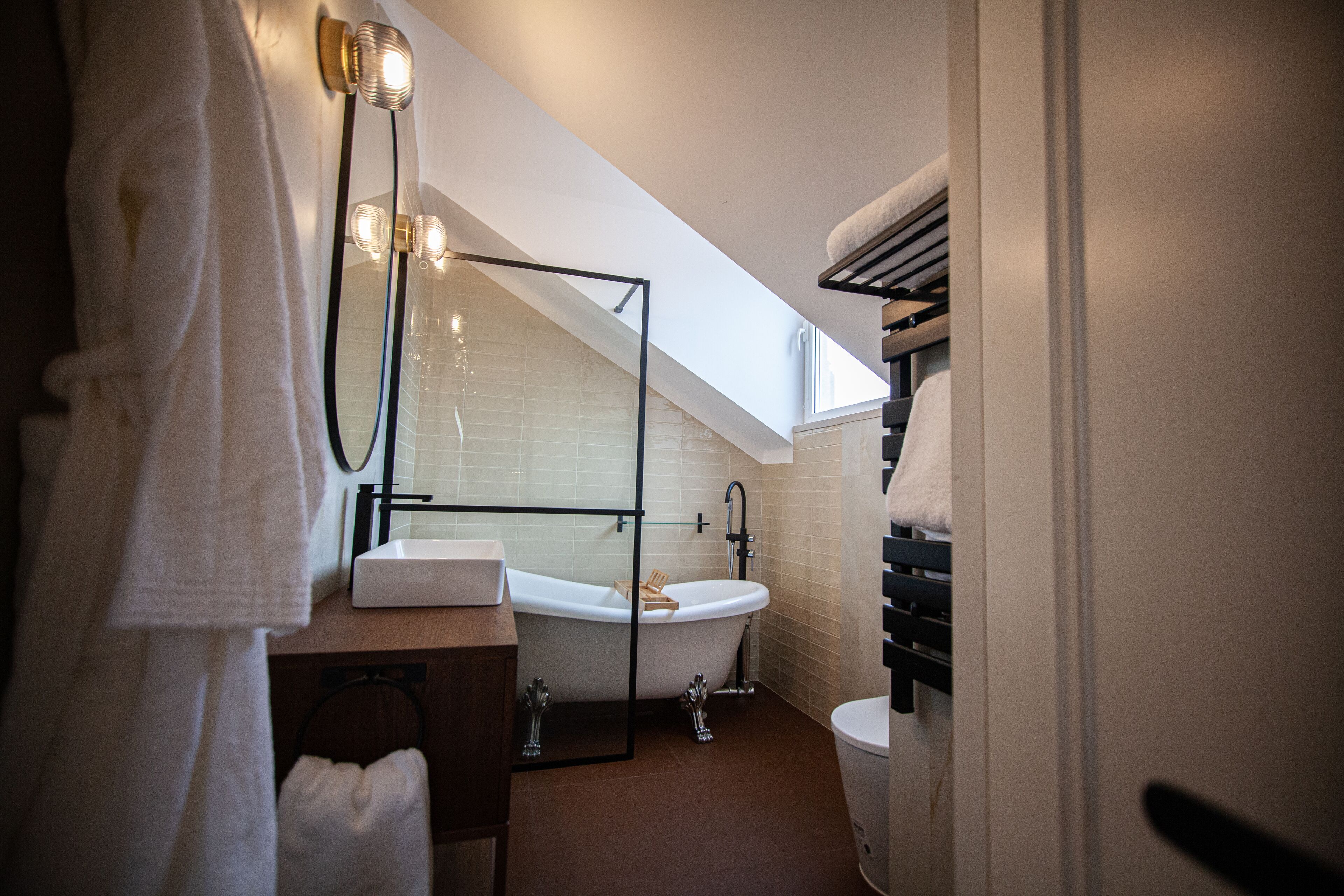 A modern bathroom with a freestanding bathtub, a glass-enclosed shower, and a toilet.
