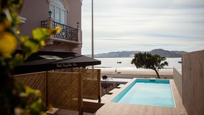 Zona de piscina con vista a la playa y las montañas.