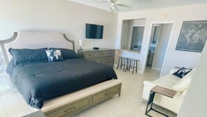 A bedroom with a bed, a desk, a chair, a dresser, a TV, and a ceiling fan. - Enjoy GULF FRONT sunsets in newly renovated private studio in private home. (Palm Harbor)