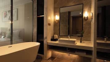 A modern bathroom with a freestanding bathtub, a large mirror, and a vanity with a sink.