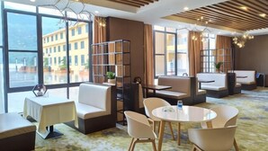 Rebedor d'hotel amb zones d'estar, una taula de cafè i una prestatgeria.