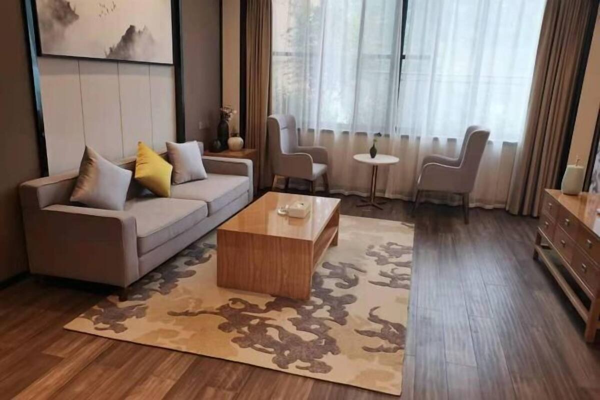 Un salon moderne avec un canapé, une table basse et deux fauteuils.