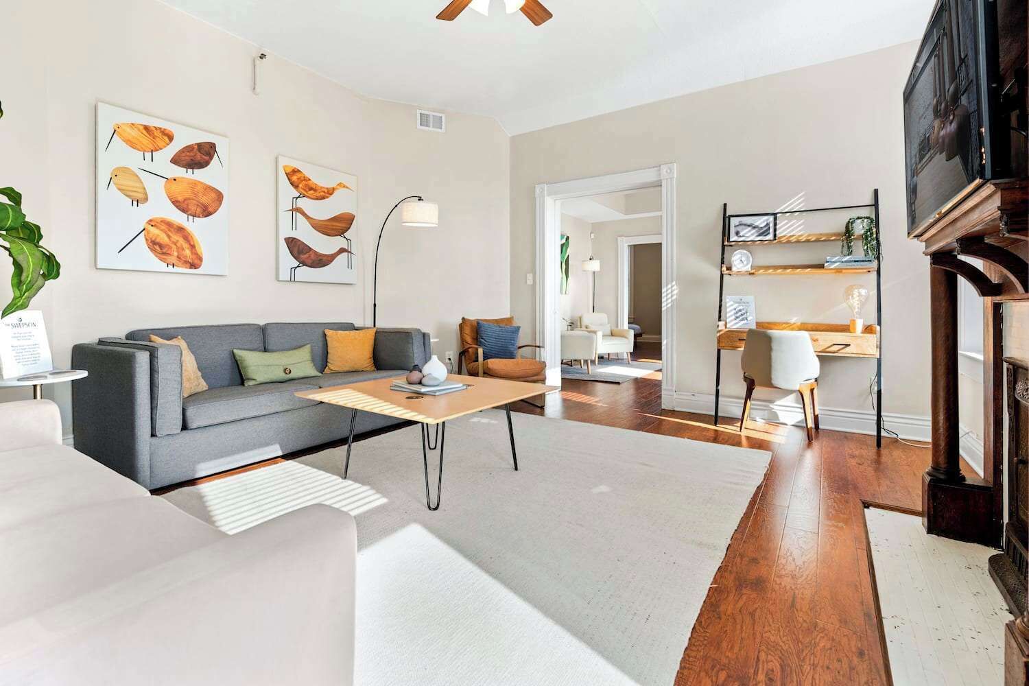 A modern living room with a grey sofa, a wooden coffee table, and a fireplace.