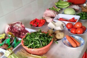 A variety of fresh produce and meat items displayed on a table.