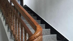 Una escalera con balaustres de madera y escalones de piedra.