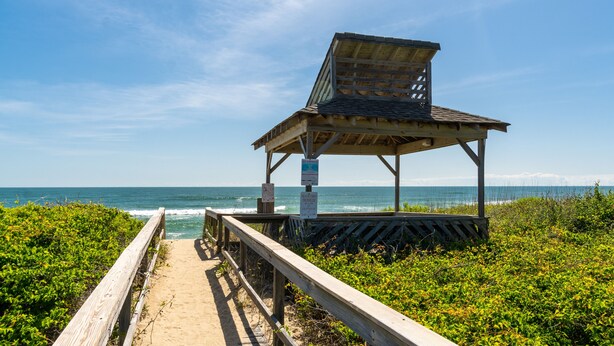 A wooden beach shelter with a slanted roof, located at the end of a wooden boardwalk beside the ocean. - Duckburgh - Ocean view, Updated, 2 min. walk to the beach (Kitty Hawk)