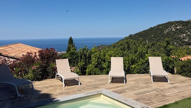 A pool with lounge chairs, a clear sky, and a view of the sea. - Magnificent pool villa with sea, lake and mountain views (Santa reparata di balagna)