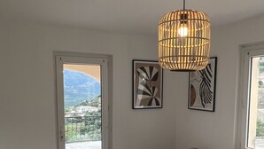 A bedroom with a bed, a hanging light fixture, and two framed artworks on the wall. - Magnificent pool villa with sea, lake and mountain views (Santa reparata di balagna)