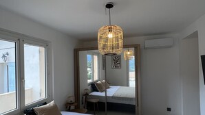 A bedroom with a large bed, a window, and a hanging light fixture. - Magnificent pool villa with sea, lake and mountain views (Santa reparata di balagna)