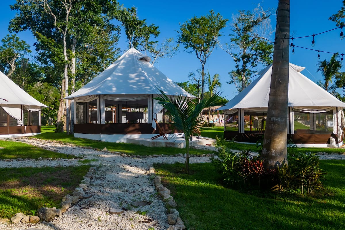 A series of white tents with a central structure featuring a covered patio area.