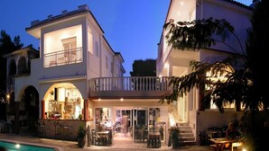 A two-story building with a bar area, outdoor seating, and a pool. - Melissa Gold Coast (Polygyros)