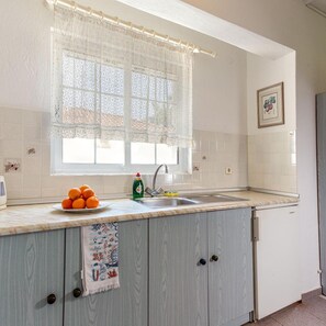 A kitchen with a window, sink, and a towel hanging on the cabinet. - Melissa Gold Coast (Polygyros)