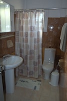 A bathroom with a sink, toilet, and shower curtain.