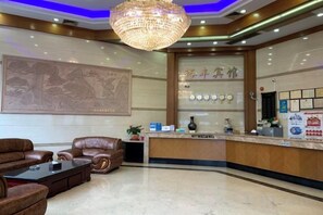 A hotel lobby with a reception desk, seating area, and a chandelier. - Shunde Yufeng Hotel (Foshan)