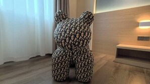 A room with a wooden floor, a bear-shaped cushion, a wall-mounted light, and a small shelf. - Shunde Yufeng Hotel (Foshan)