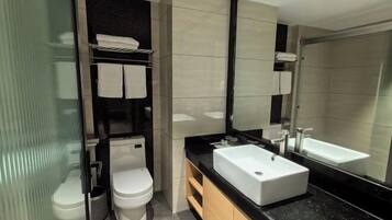 Een moderne badkamer met toilet, wastafel en een grote spiegel.