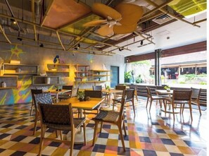 A restaurant with a checkered floor, wooden furniture, and a view of the outside.