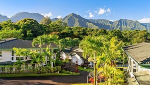 Un quartiere residenziale con case, una strada asfaltata e vegetazione rigogliosa.