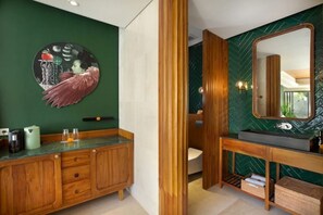 Bathroom features a vanity with a sink and cabinet, a large mirror, and a unique circular artwork.