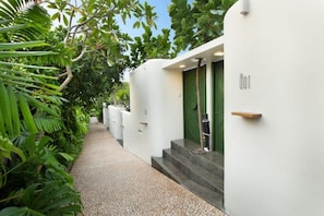 Steps lead to a serene entrance surrounded by lush greenery.