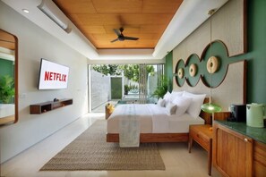 Relax in this serene bedroom with a large bed, ceiling fan, and flat-screen TV.