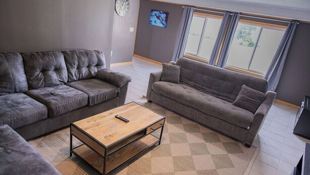 A living room with two grey sofas, a wooden coffee table, and a patterned rug. - Lake Cabin on North Long Lake (Brainerd)