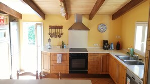 A kitchen with wooden cabinets, a dishwasher, a stove, and a sink.