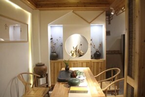 Ein Essbereich mit Holztisch, Stühlen und einer zentralen Blumenanordnung.