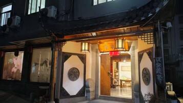 A traditional building with a wooden entrance, large windows, and a sign with Chinese characters.