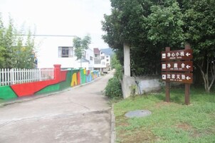 Un sendero que conduce a un edificio con un cartel que indica las direcciones a diferentes instalaciones.