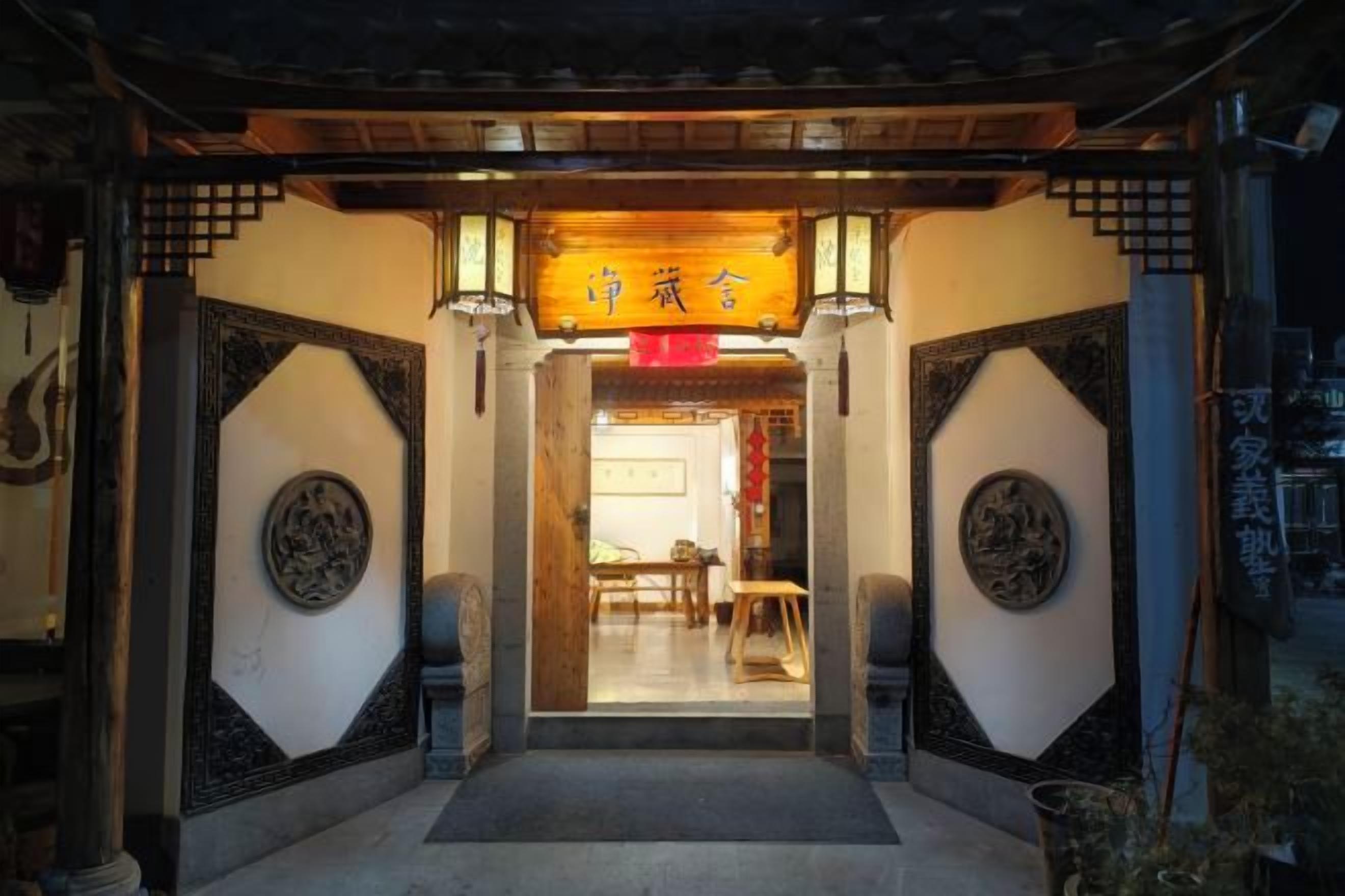 A traditional entrance with a wooden archway and a sign above it.
