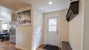 A modern kitchen with a refrigerator, a dining table, and a bench. - The Silver Mountain Chalet- Private Hot Tub! (Kellogg)
